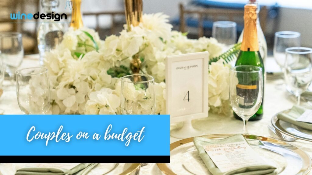Wedding reception table setting featuring custom labelled red wine bottles as centrepieces