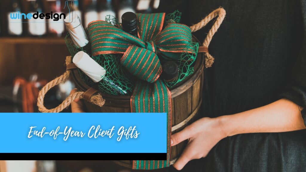 Where Wine Bottles Fit into Corporate Programs - Wine Bottles A person holding a round wooden gift basket filled with wine bottles and decorated with a large green and red striped bow.