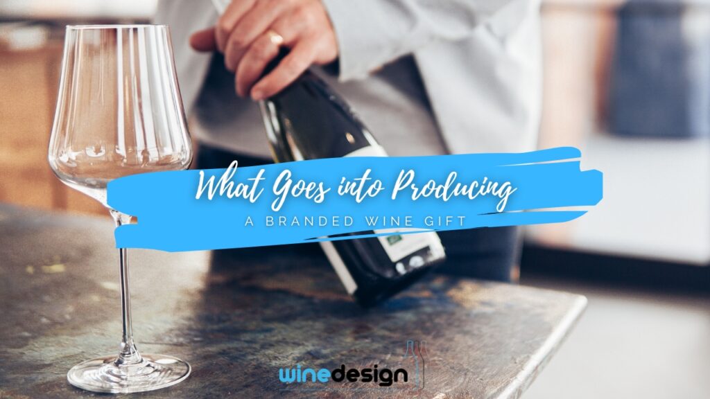 Blog - Wine An empty wine glass stands on a countertop in the foreground while a person opens a wine bottle in the blurred background