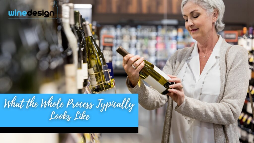 What Goes into Producing a Branded Wine Gift - Wine A woman in a store smiles as she examines a bottle of white wine taken from a shelf display.
