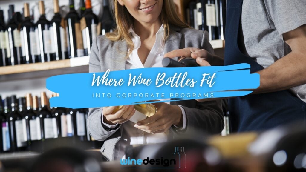 Blog - Wine A woman in a grey blazer smiles while looking at a wine bottle presented by a staff member in a wine cellar.