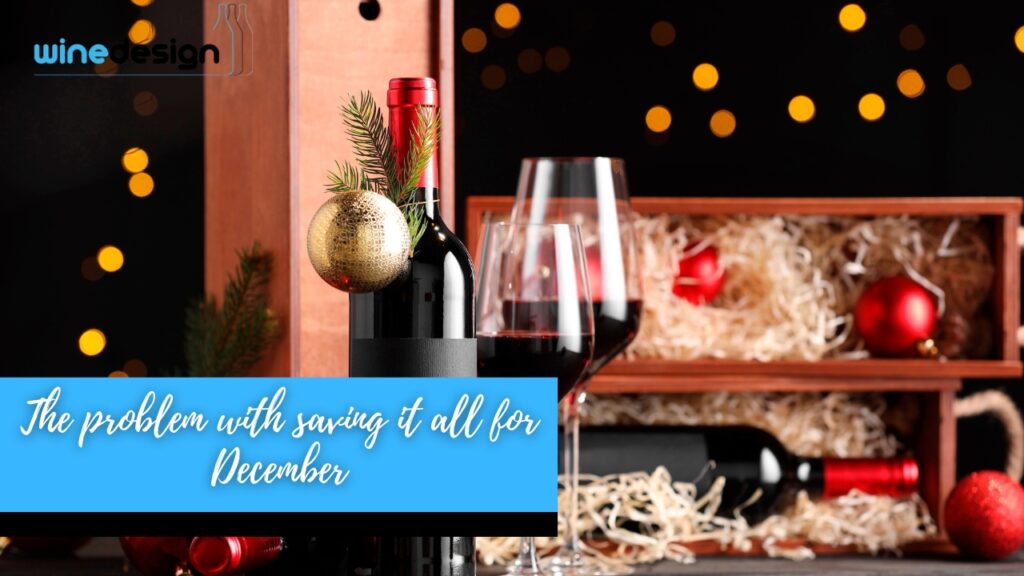 Branded Wine Bottles That Keep Clients Connected - Bottles A wine bottle decorated with a Christmas ornament and pine sprig next to glasses of red wine and holiday decorations.